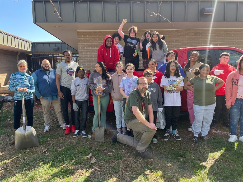 Students at Robinson Middle School pose for photo after starting their new community garden on the school grounds.
